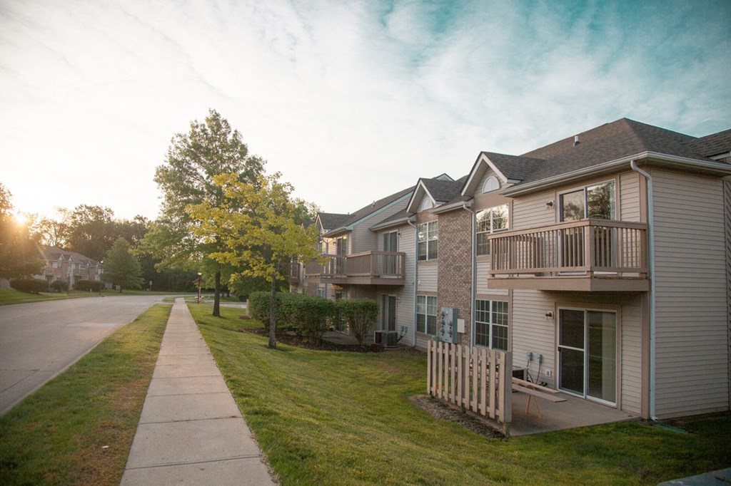 a row of houses on the side of a sidewalk