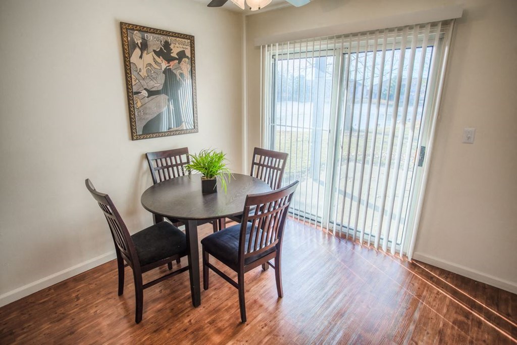 a dining room with a table and chairs and a window