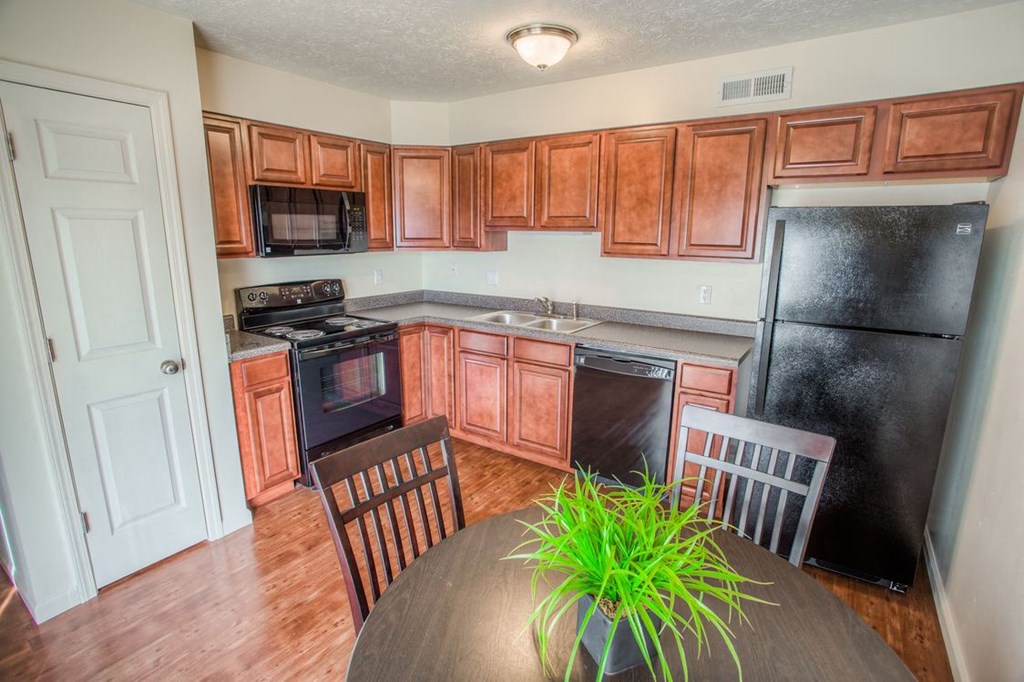 a kitchen with wooden cabinets and a table with chairs
