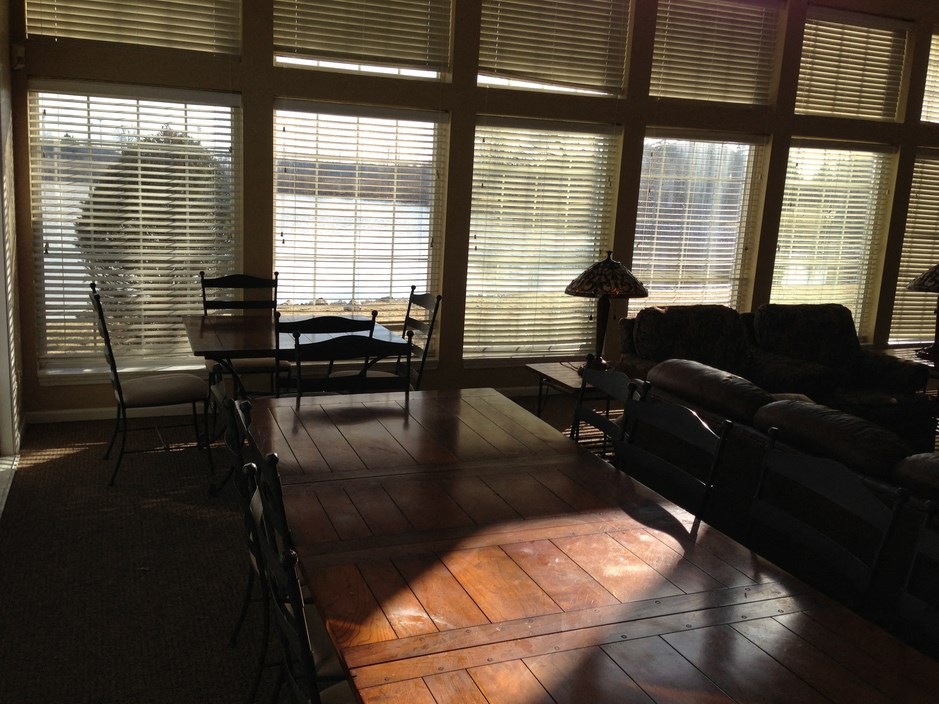 a living room with large windows and a table and chairs