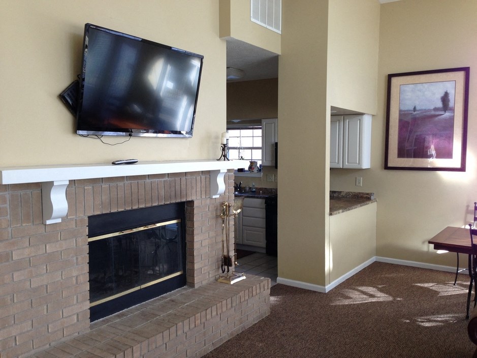 a living room with a fireplace and a television on the wall