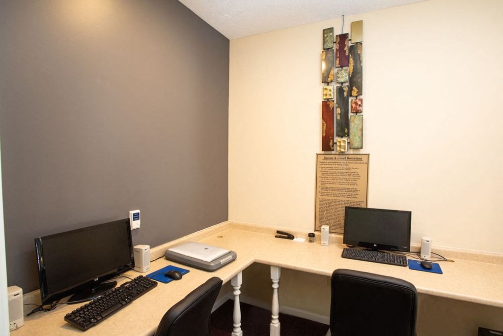 a desk with two computers on it in a room