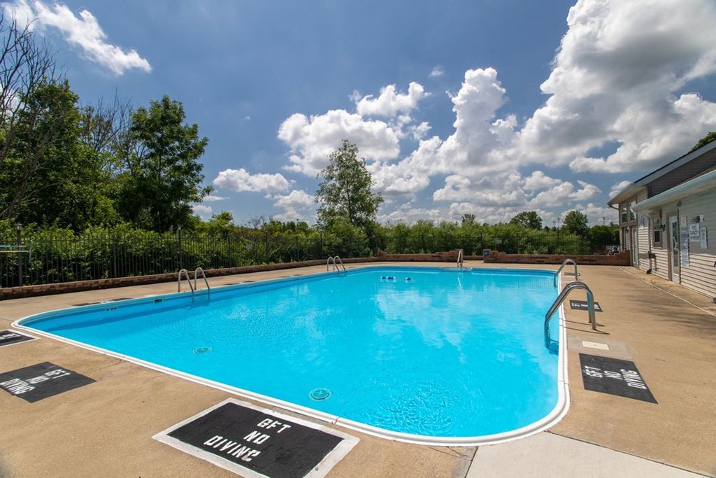 a swimming pool at a hotel with a cloudy sky above it