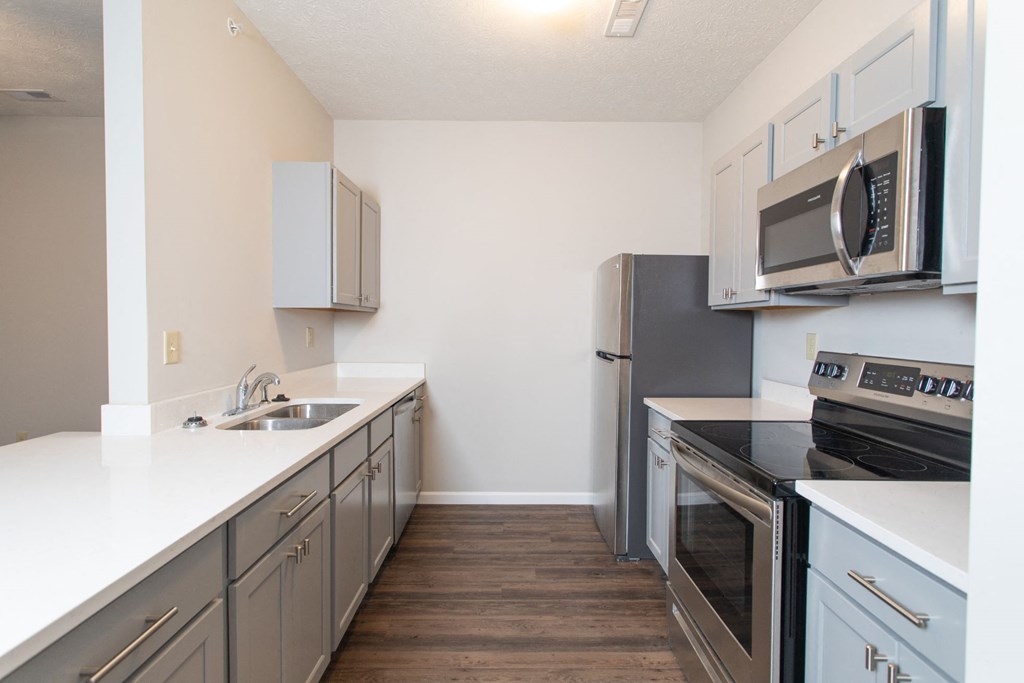 a kitchen with stainless steel appliances and white counter tops