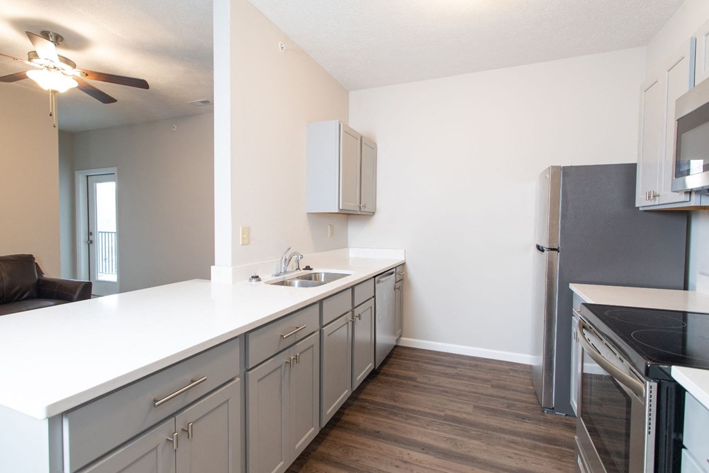 a kitchen with a white counter top and a stainless steel refrigerator