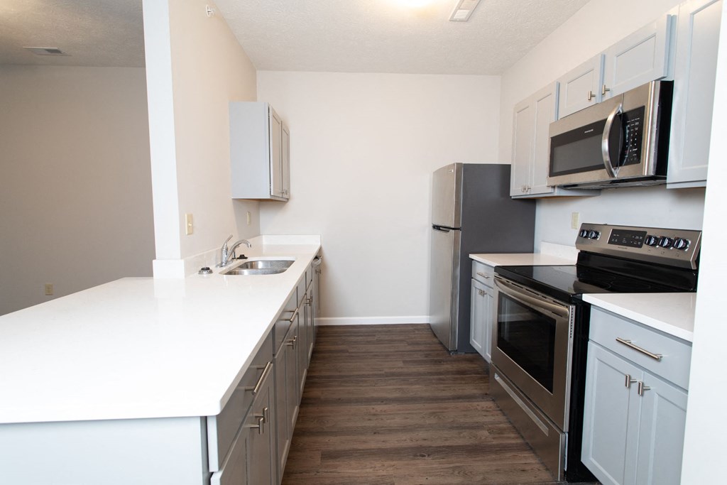 a kitchen with white countertops and stainless steel appliances