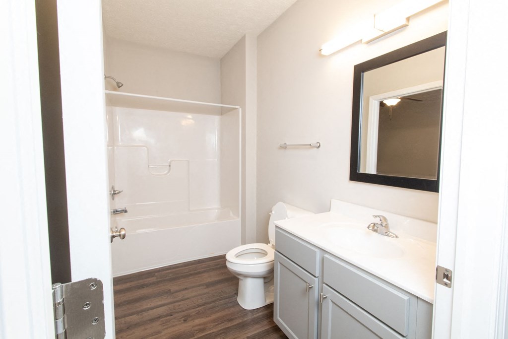 a bathroom with a toilet sink and shower and a mirror