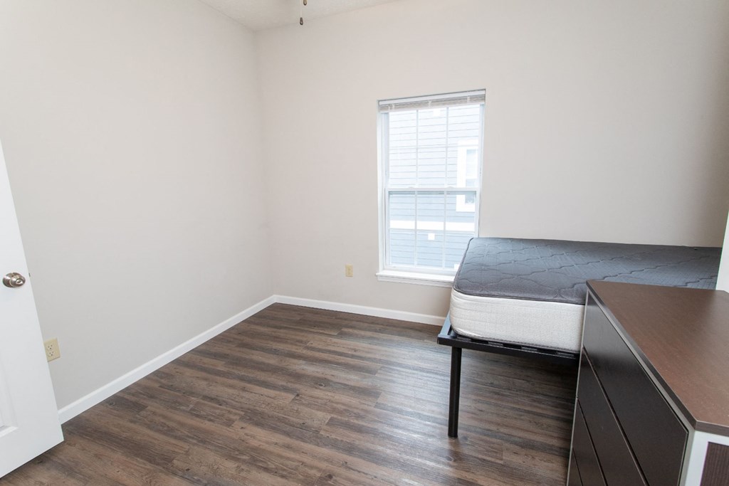 a bedroom with a bed and a desk and a window