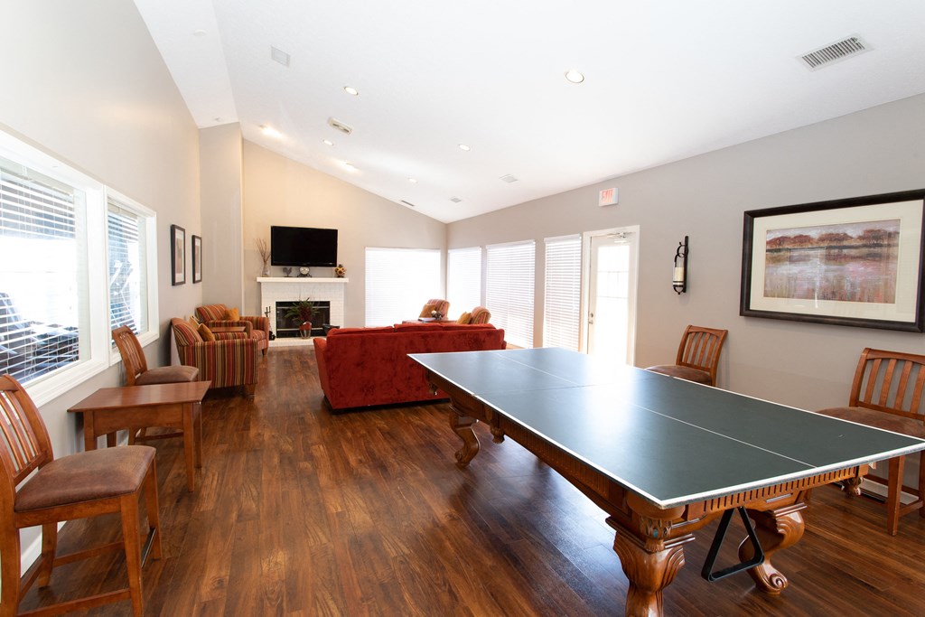 a living room with a ping pong table and a fireplace