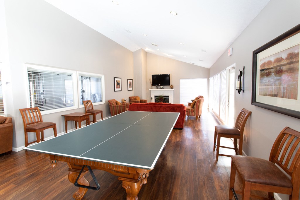 a living room with a ping pong table and a fireplace