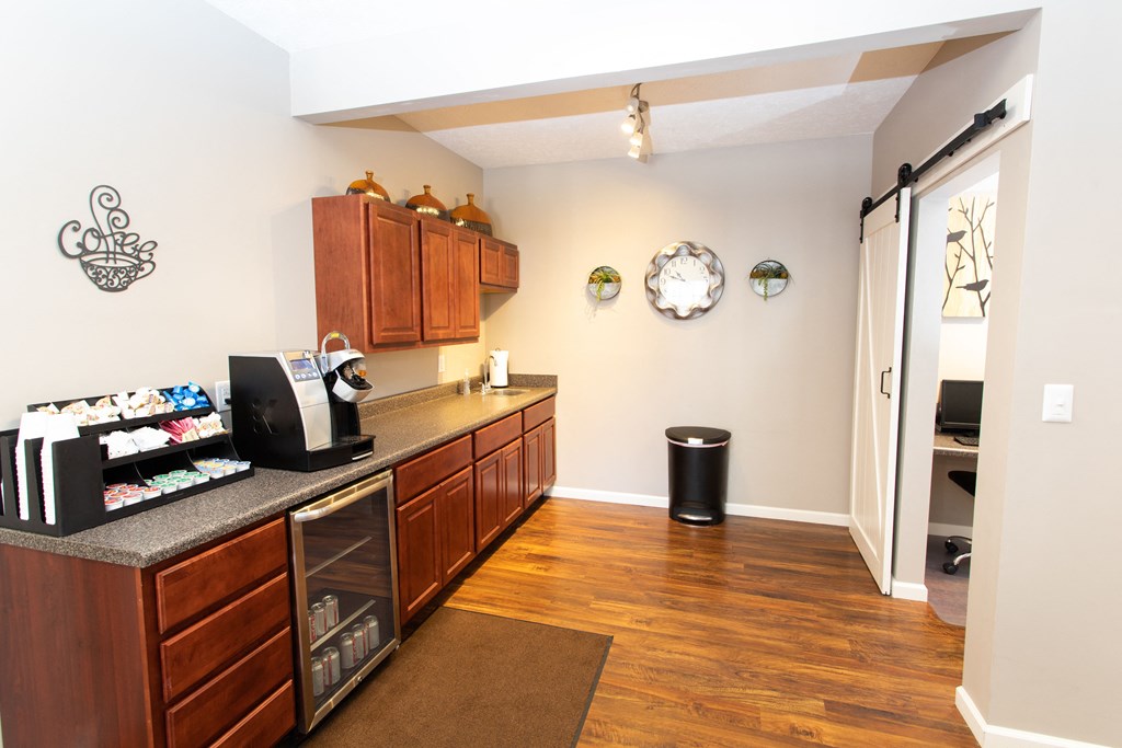 a kitchen with wooden cabinets and a counter top and a door to a living room