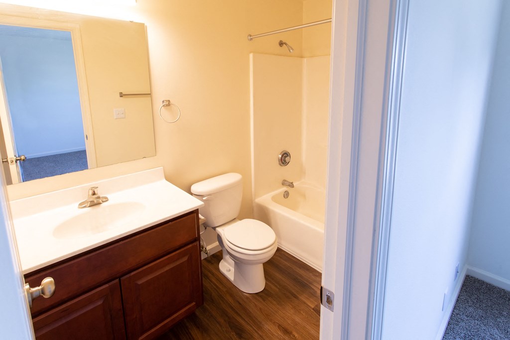 a bathroom with a toilet sink and tub and a mirror