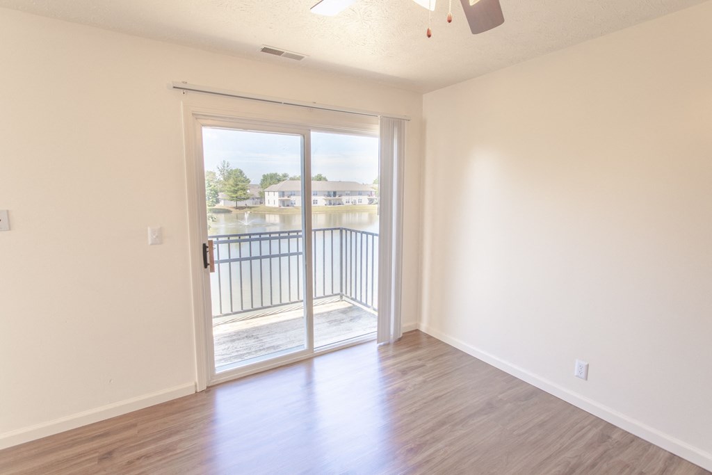 an empty living room with a door to a balcony