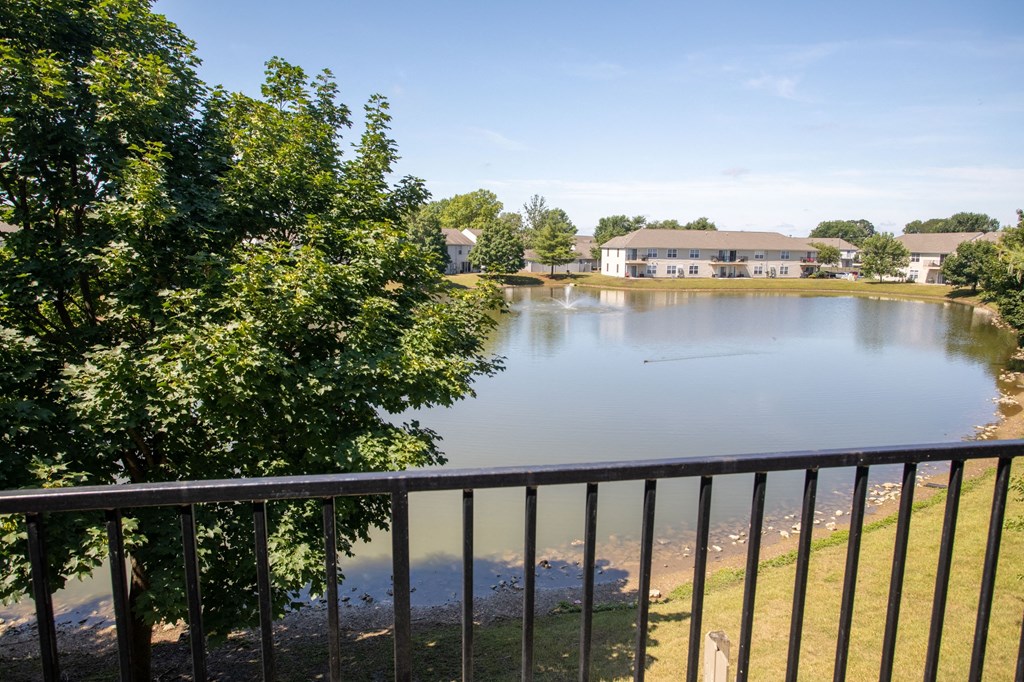 a view of a lake from a balcony with a building in the background