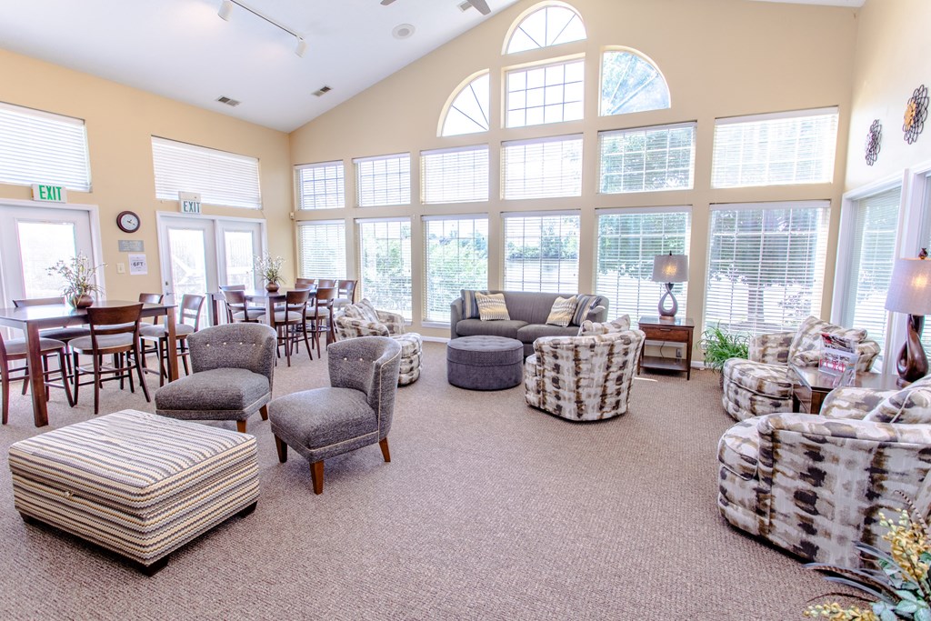 a living room filled with furniture and large windows