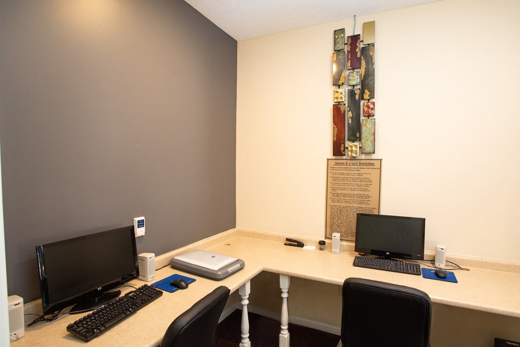 a desk with two computers on it in a room