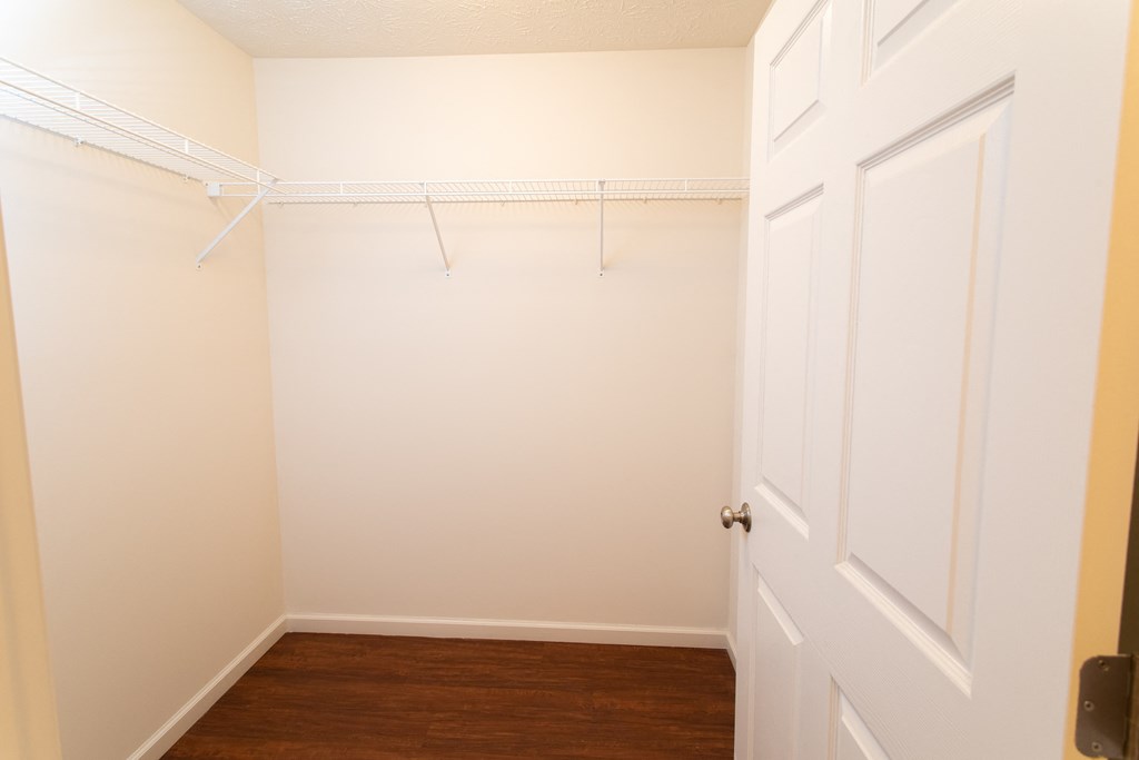 an empty room with a white closet and a door