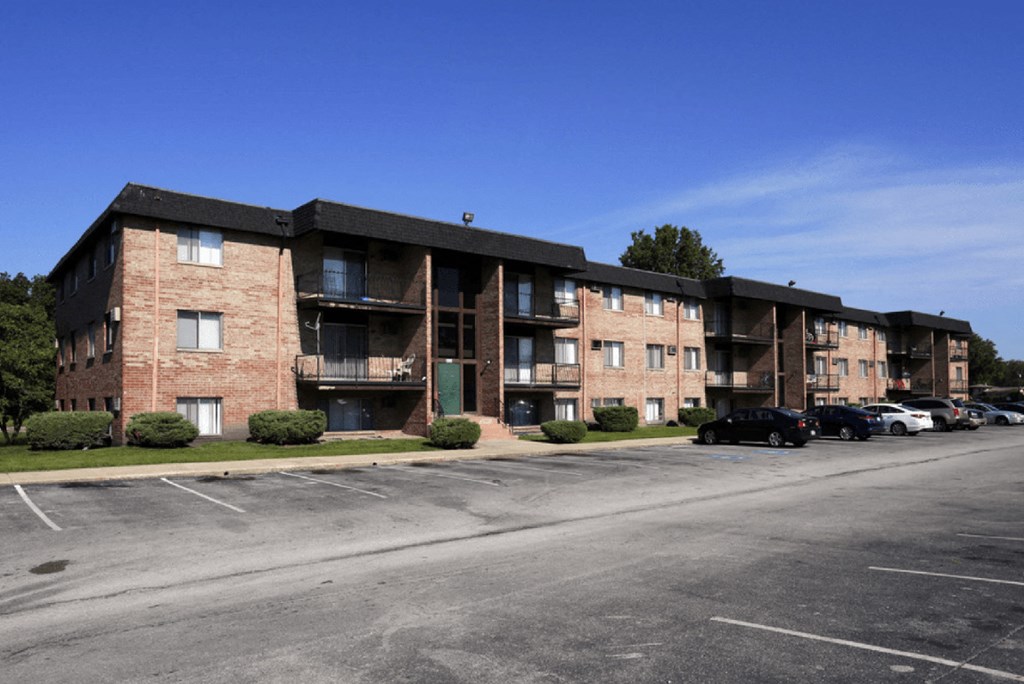 an apartment complex with a parking lot in front of it