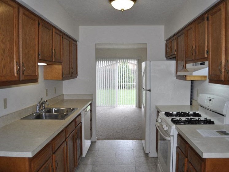 a kitchen with a white refrigerator freezer next to a stove top oven