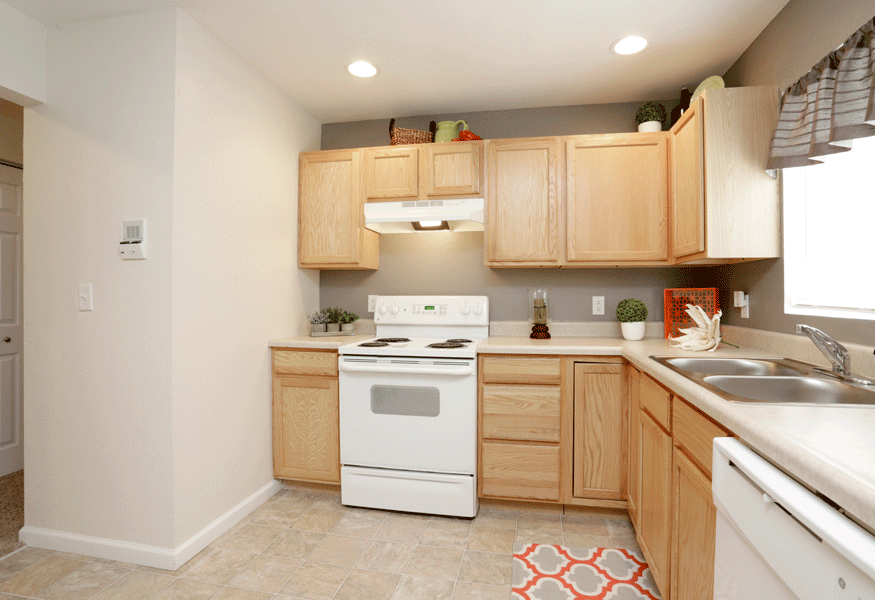 a kitchen with wooden cabinets and white appliances