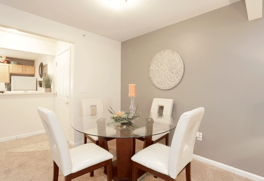 a dining room with a glass table and white chairs