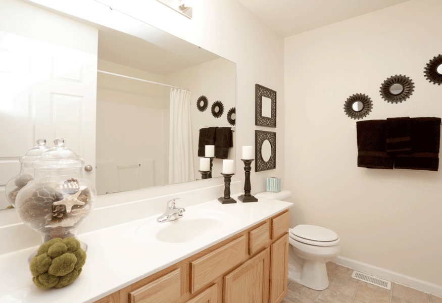 a bathroom with white walls and a large mirror