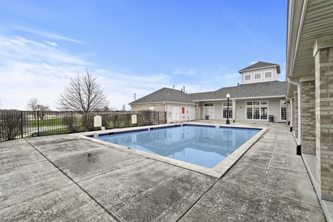 A large outdoor swimming pool in front of a house.