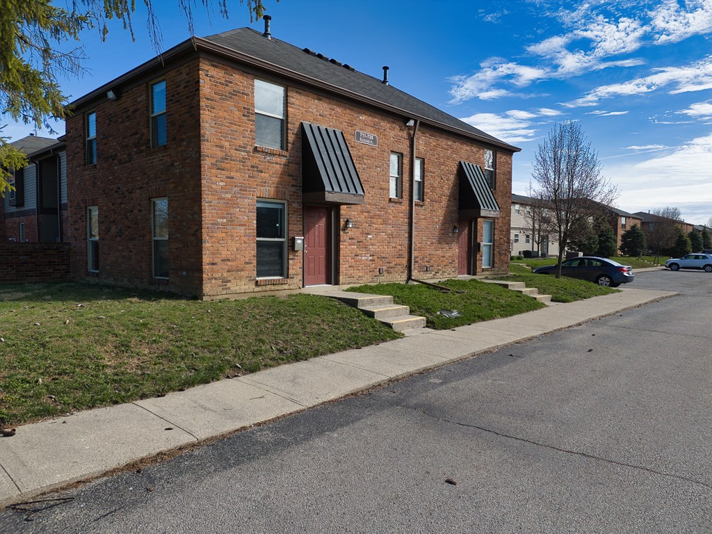 a brick apartment building on the corner of a street