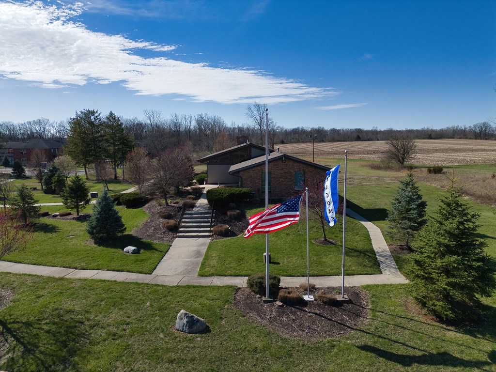 an aerial view of a house with two flags in front of it
