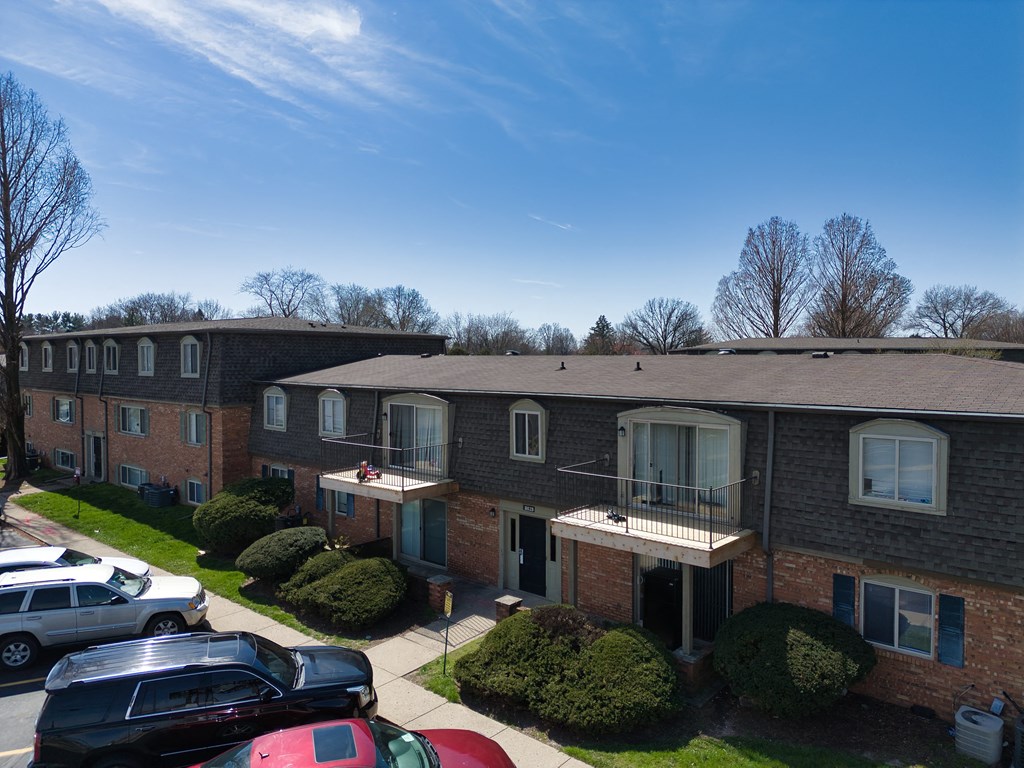 an aerial view of a brick apartment building with a parking lot