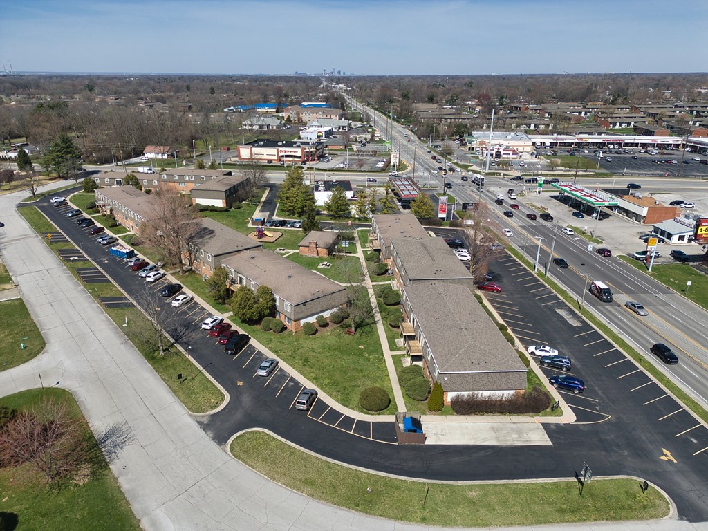 an aerial view of a parking lot with several buildings and a highway