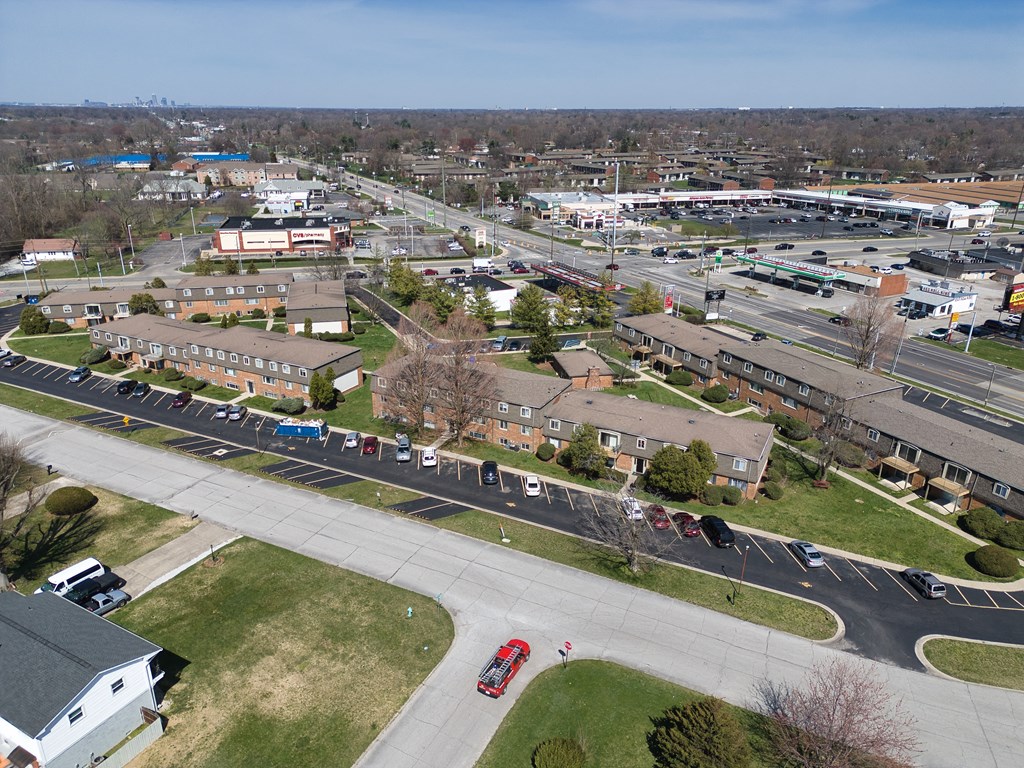 an aerial view of a city with cars parked in a parking lot