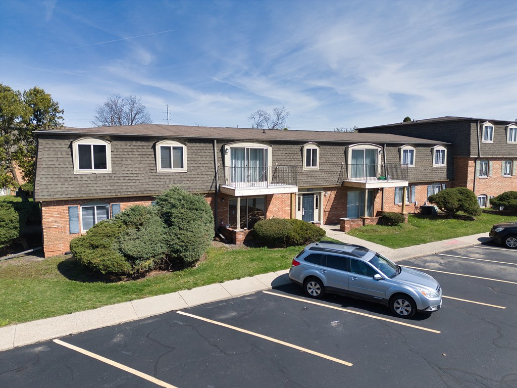 an apartment building with a car parked in front of it