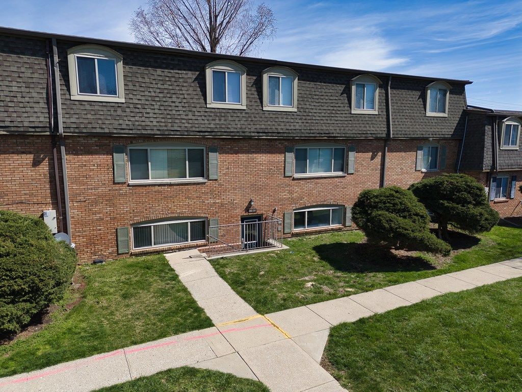 a brick house with a sidewalk in front of it
