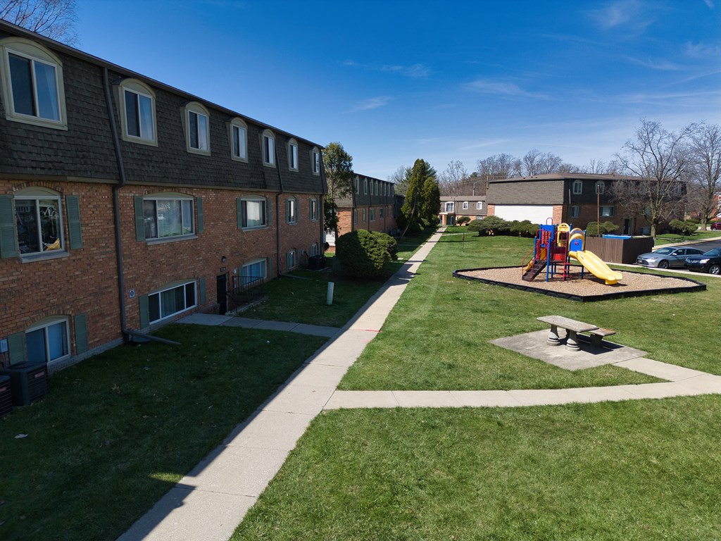 a playground in a yard in front of a brick building