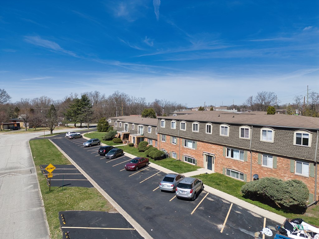 an aerial view of an apartment complex with cars parked in a parking lot