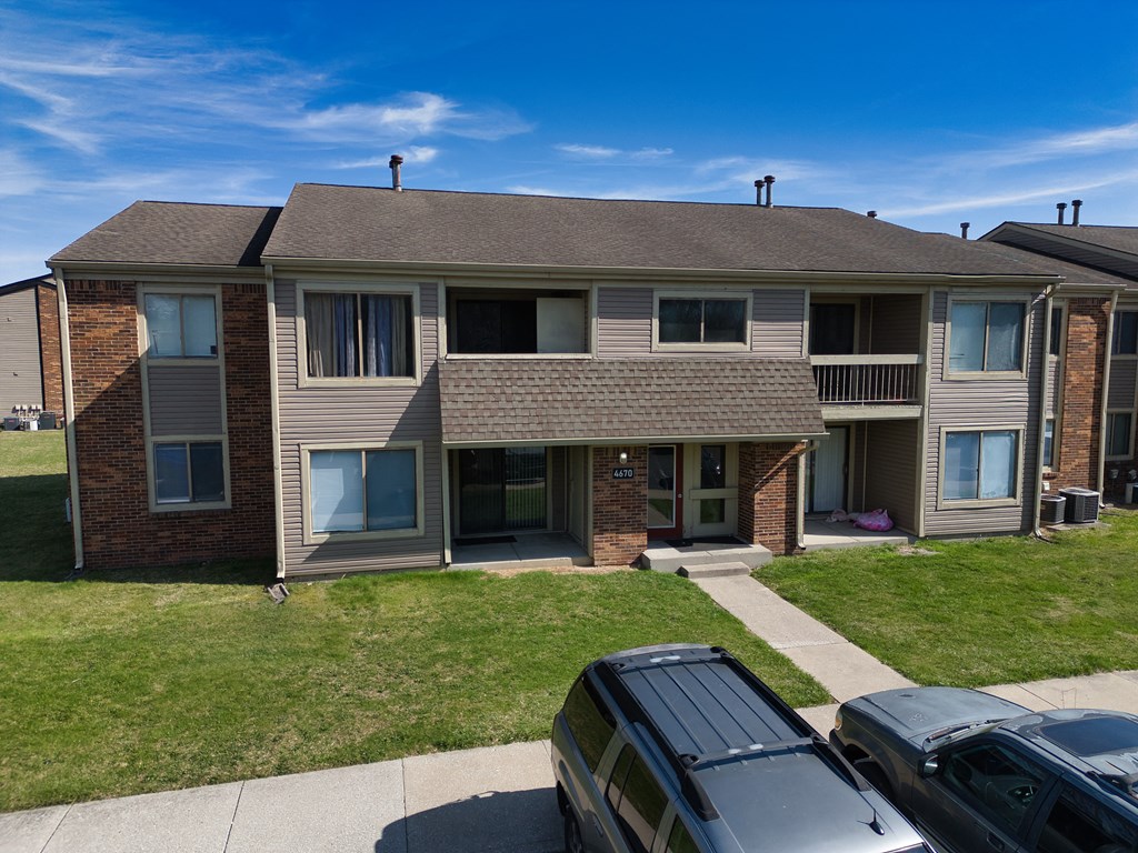 an apartment building with cars parked in front of it