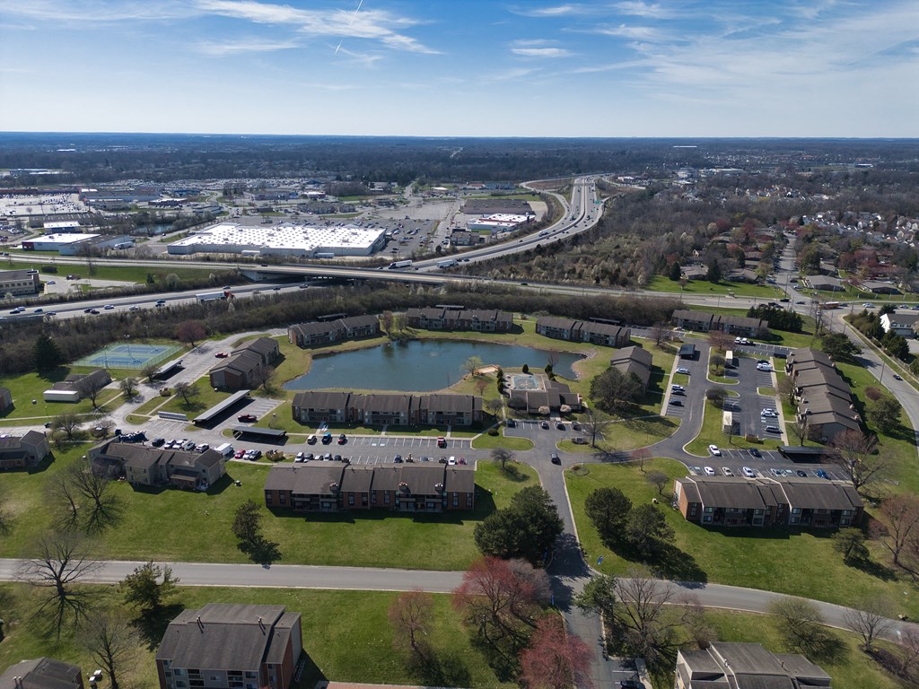 an aerial view of a park with a lake and buildings