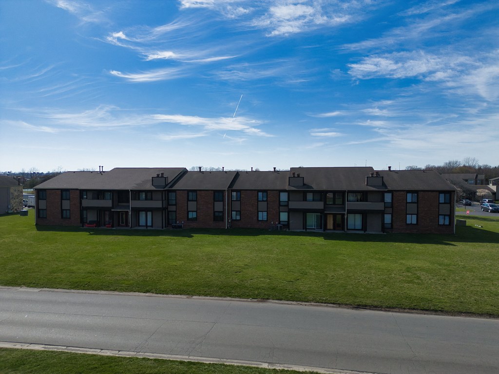 an apartment building on the side of a road with a blue sky
