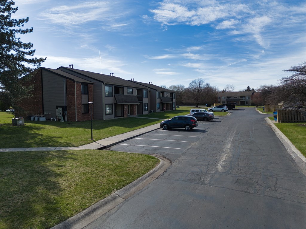 an apartment complex with cars parked in a parking lot