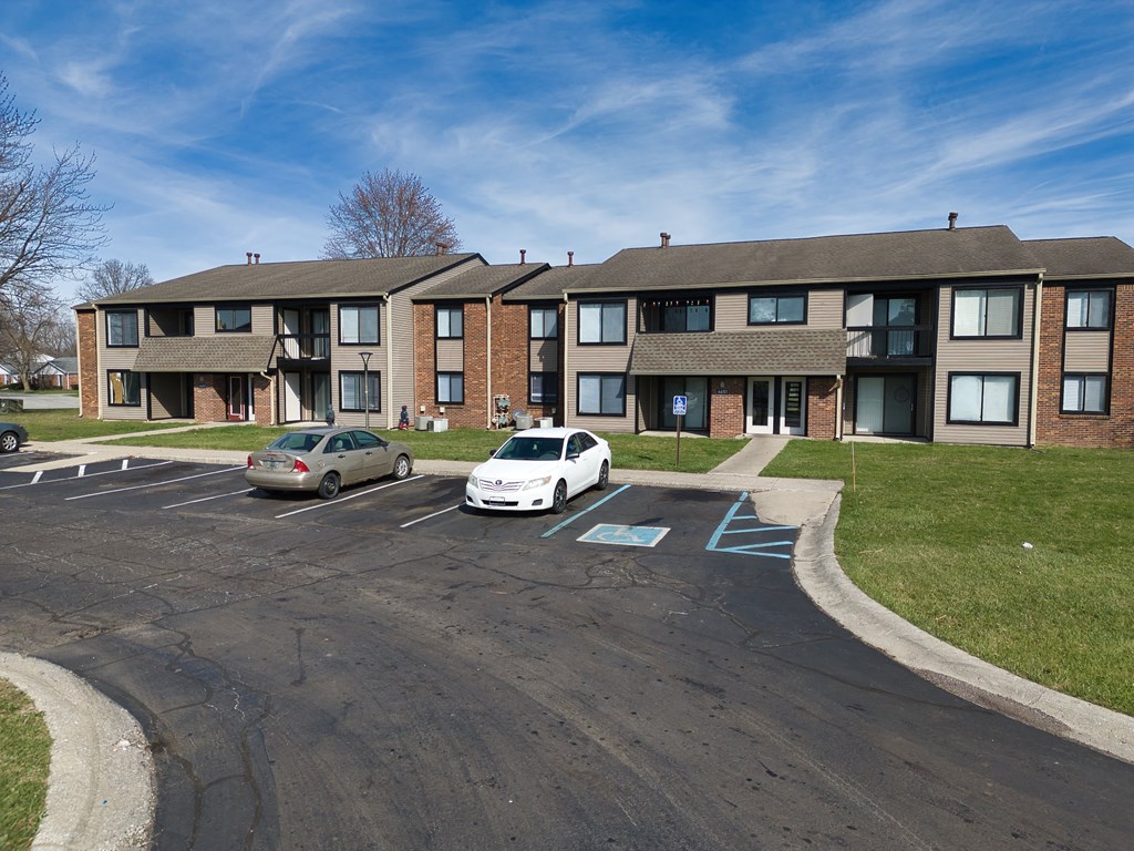an apartment building with cars parked in front of it