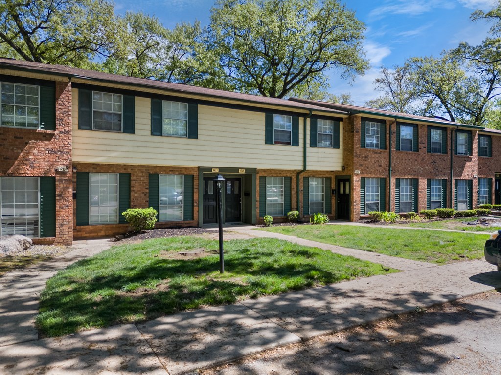 an apartment building with a sidewalk in front of it