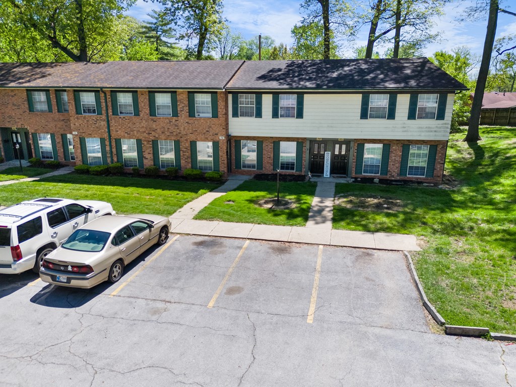a large brick house with cars parked in front of it