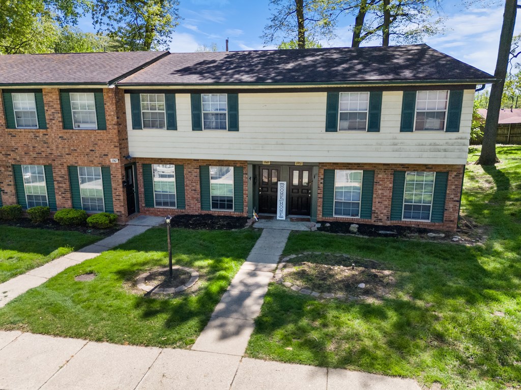 the front of a house with a sidewalk in front of it