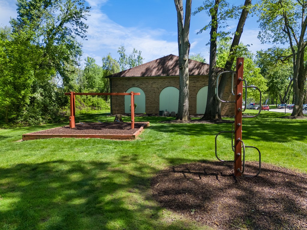 a park with a swing set and a building in the background