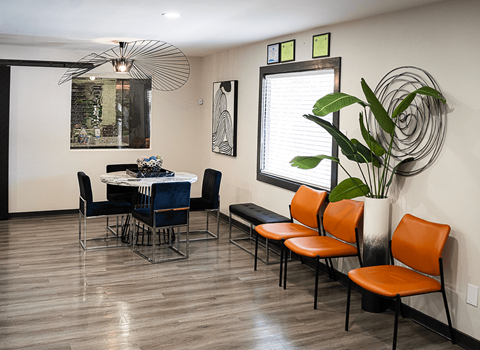 a dining room with a table and chairs and a potted plant