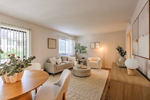 A living room with a couch, chair, and potted plant.