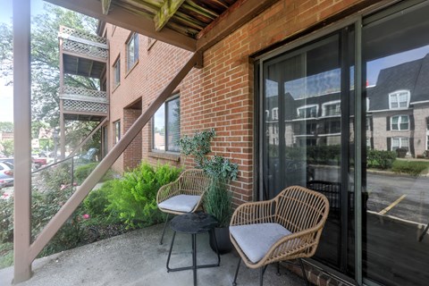 Two chairs are on a patio outside a building.