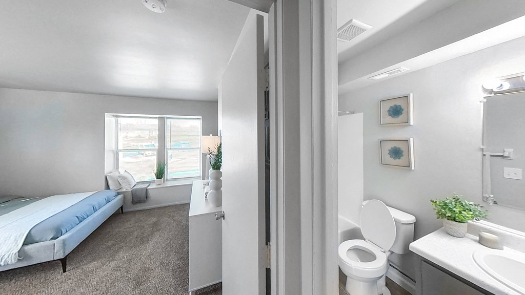 a bedroom with a bed and a bathroom with a toilet and a sink