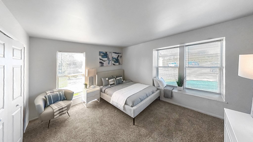 a bedroom with a bed and two windows